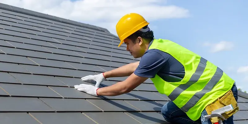 A roof inspector from Northland Roofing evaluating tile alignment during a routine roof inspection.